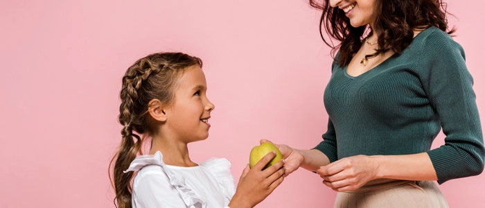 Chiropractic Dallas TX Mother Giving Apple